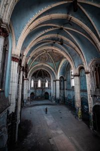 Photograph of an abandoned Gothic cathedral interior with stunning arches and decayed beauty.